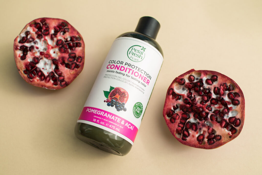 Image of Petal Fresh Pure Color Protection Pomegranate & Acai Conditioner bottle. The conditioner is enriched with natural ingredients to protect hair color, such as pomegranate and acai. The bottle is standing on a white background.